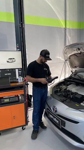 Técnico da Enovacar usando scanner no motor de um veículo para avaliação